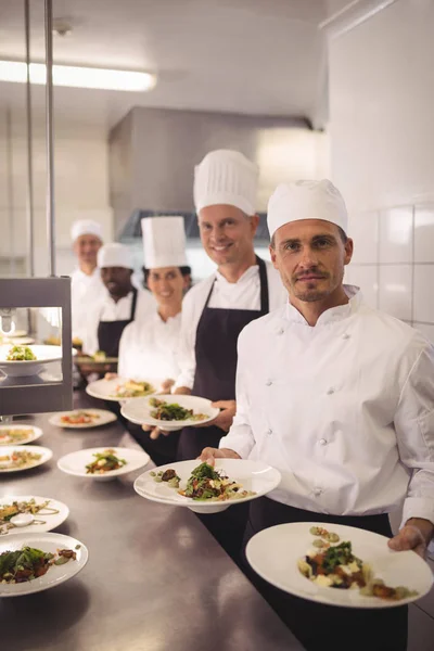 Chef-koks presenteren voedsel platen — Stockfoto