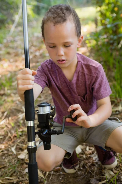 Boy adjusting the fishing rod — Stock Photo, Image