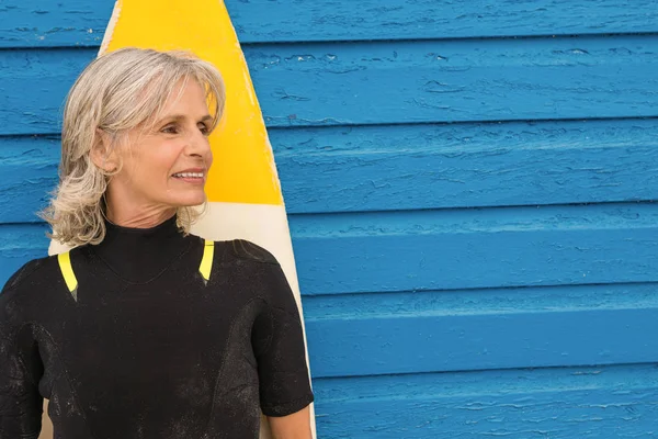 Mujer de pie con tabla de surf — Foto de Stock