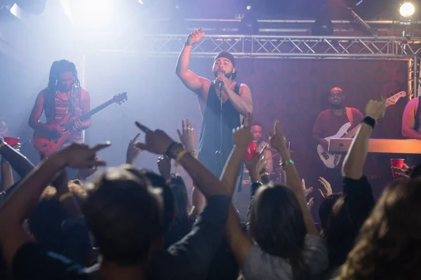 Musician with performance group singing at nightclub — Stock Photo, Image