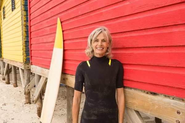 Mujer de pie con tabla de surf — Foto de Stock