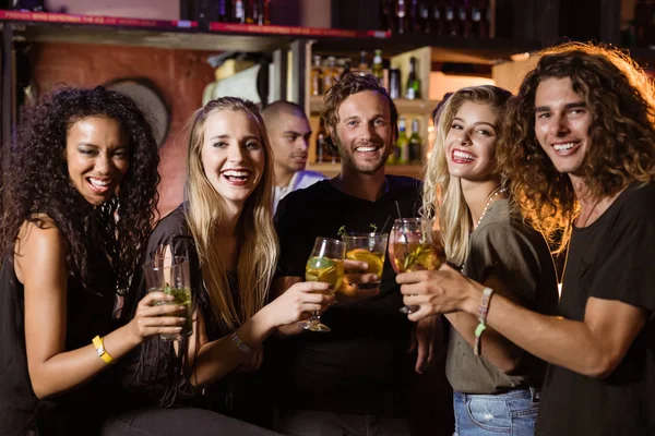 Amigos sonrientes brindando vasos de cerveza — Foto de Stock