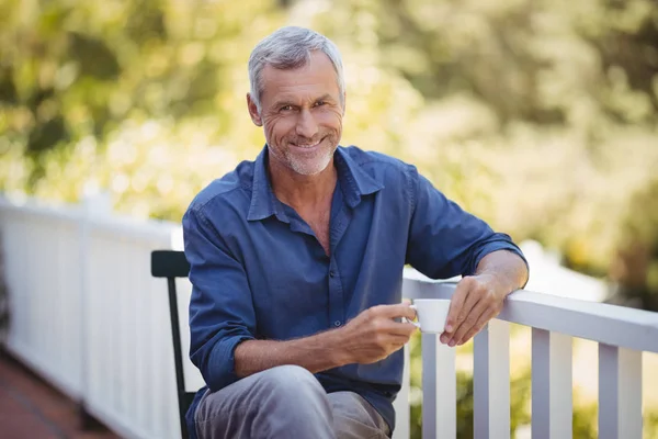 Homem tendo uma xícara de café na varanda — Fotografia de Stock