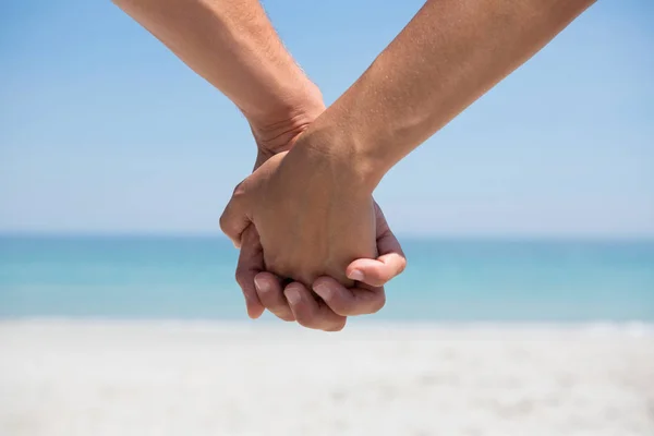 Обрезанные руки пары держатся за руки — стоковое фото
