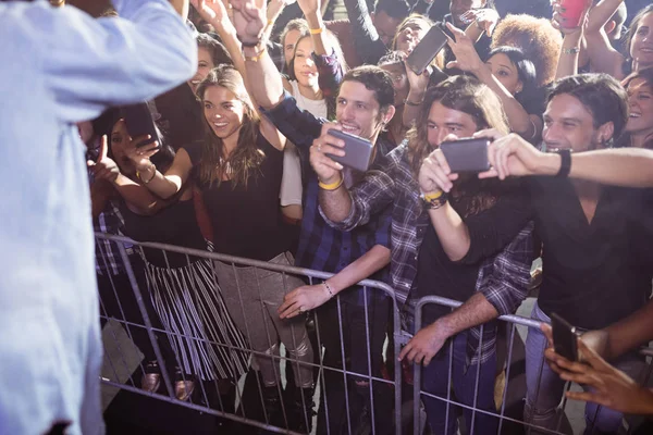 Veselá fanoušky fotografování umělec v nočním klubu — Stock fotografie