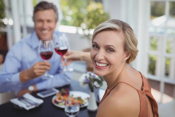 Casal brindar copo de vinho enquanto tendo refeição — Fotografia de Stock