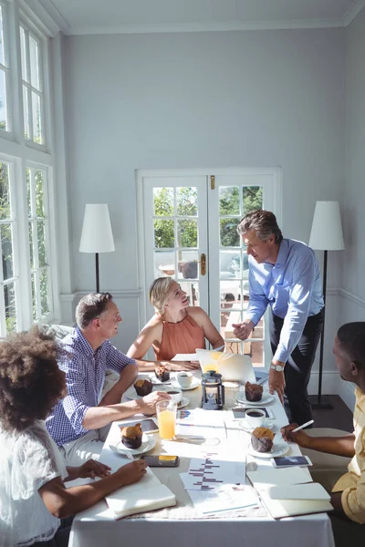 Ejecutivo usando el ordenador portátil mientras desayuna — Foto de Stock