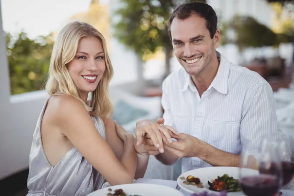 Man sätta förlovningsring på kvinnans hand — Stockfoto