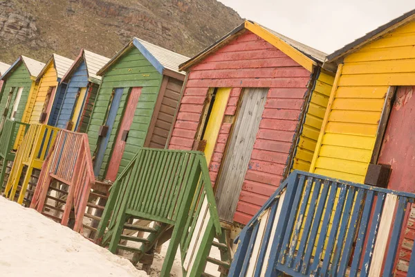 Разноцветные деревянные хижины на песке — стоковое фото