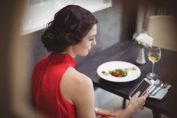 Kobieta przy użyciu telefonu podczas posiłku — Zdjęcie stockowe