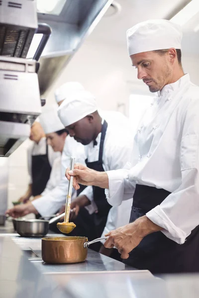 Equipe de chefs preparando comida na cozinha — Fotografia de Stock