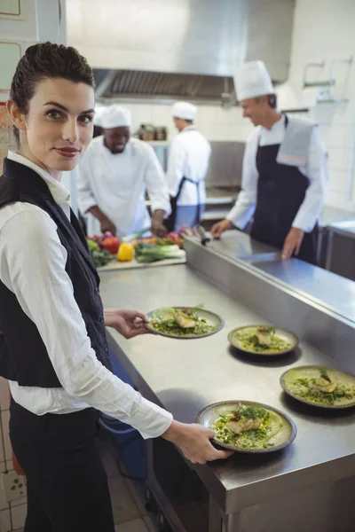 Kellnerin zeigt Geschirr in die Kamera — Stockfoto