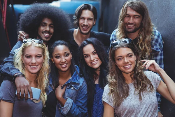 Retrato de amigos sonrientes por la pared — Foto de Stock