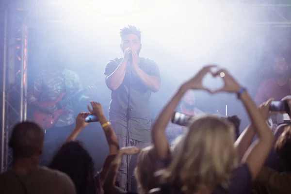 Male singer performing in front of crowd — Stock Photo, Image