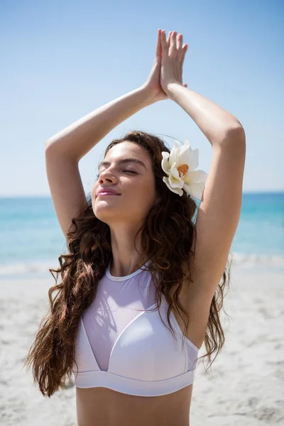 Mujer con los ojos cerrados haciendo ejercicio en la playa —  Fotos de Stock