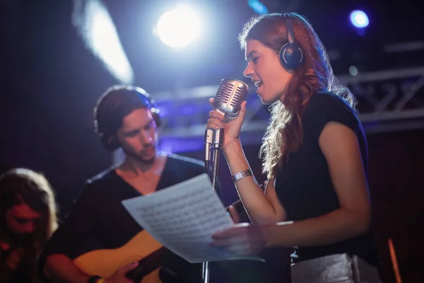 Cantante usando auriculares mientras canta — Foto de Stock