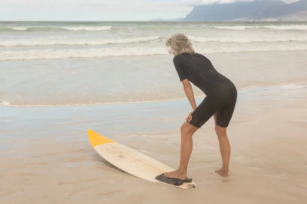 Жінка з дошкою для серфінгу на пляжі — стокове фото