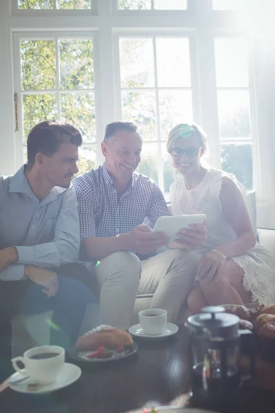 Amigos usando tablet enquanto toma café da manhã — Fotografia de Stock