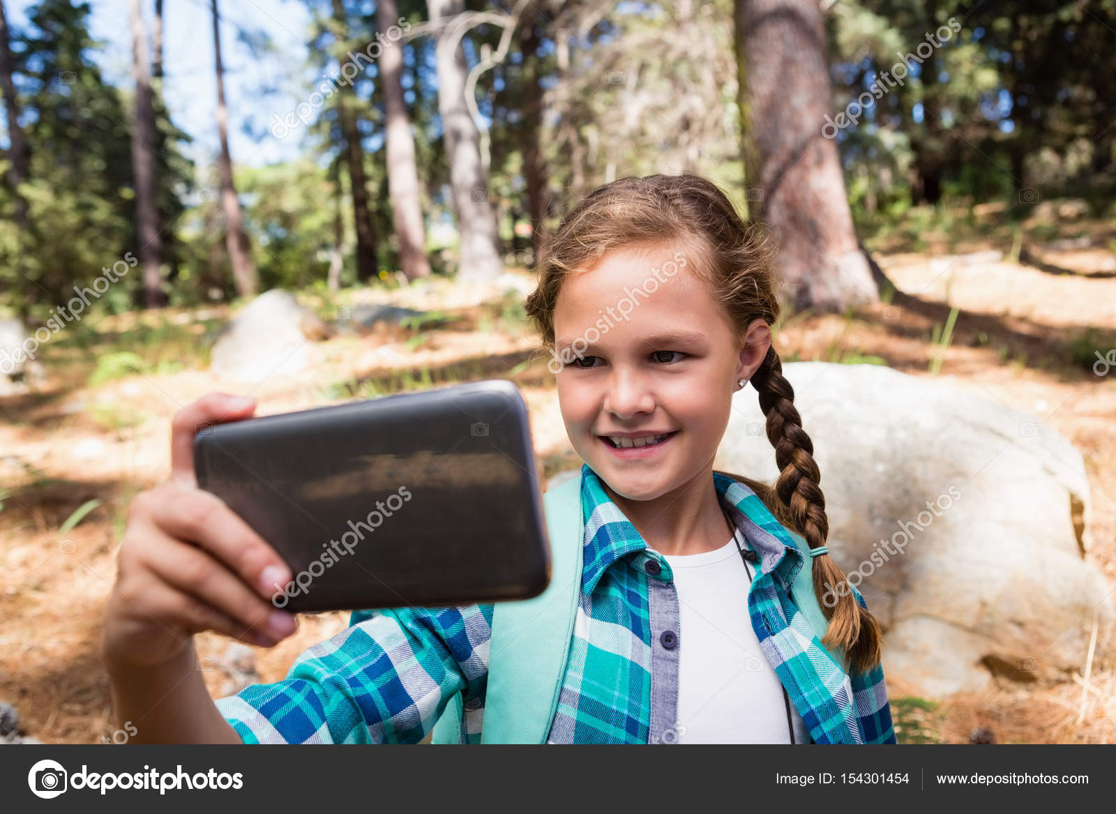 Girl taking a selfie in the forest Stock Photo by ©Wavebreakmedia 154301454