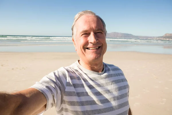 समुद्र तट वर उभे आनंदी वरिष्ठ माणूस — स्टॉक फोटो, इमेज
