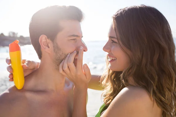 Woman applying sunscreen on man face — Stock Photo, Image