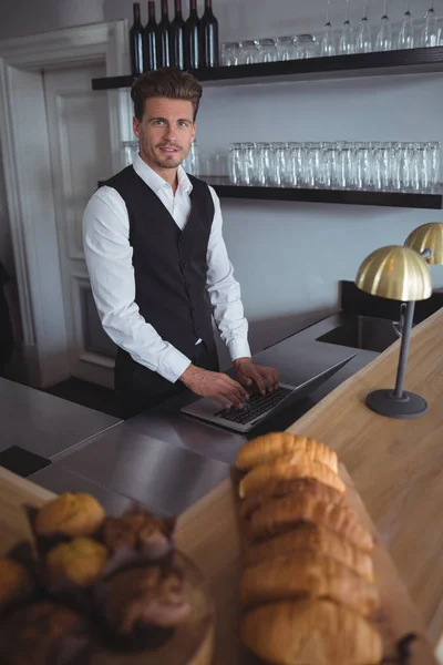 Cameriere con computer portatile al bancone — Foto Stock