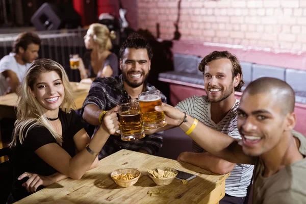 Amigos tostando tazas de cerveza en el club nocturno —  Fotos de Stock
