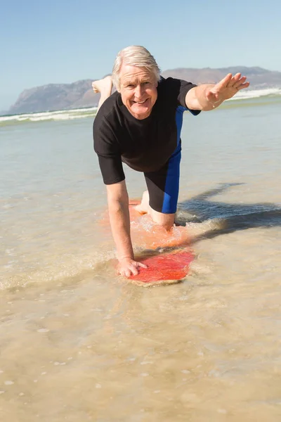 Homem exercitando na prancha de surf em terra — Fotografia de Stock