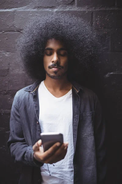 Man met mobiele telefoon tegen muur — Stockfoto