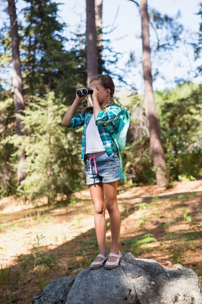 Girl looking through binoculars — Stock Photo, Image