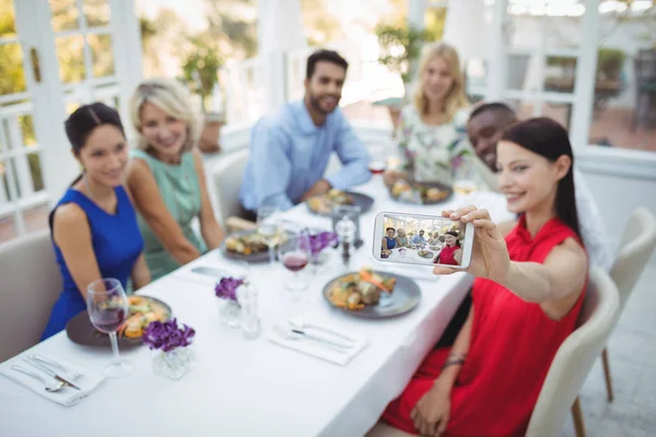 Friends taking selfie on phone while having meal — Stock Photo, Image