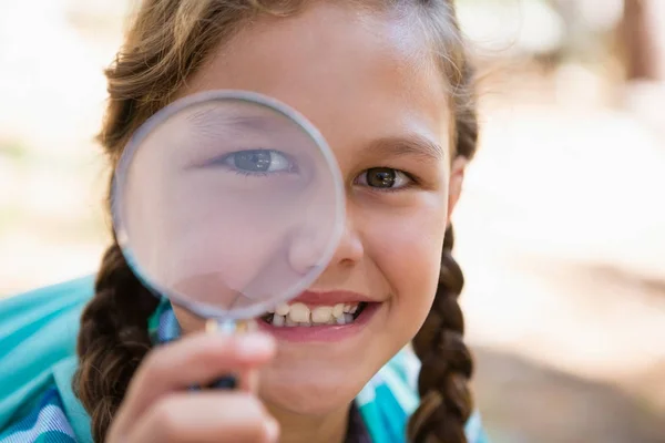 Girl looking through magnifying glass — Stock Photo, Image