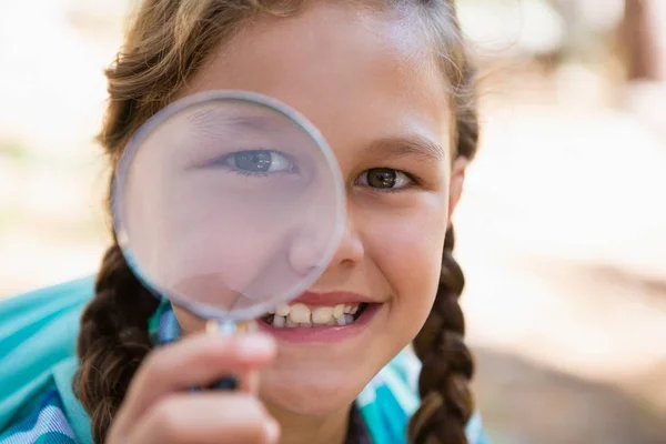 Flicka tittar genom förstoringsglas — Stockfoto