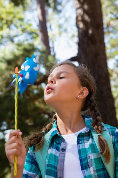 Menina soprando um pinwheel — Fotografia de Stock