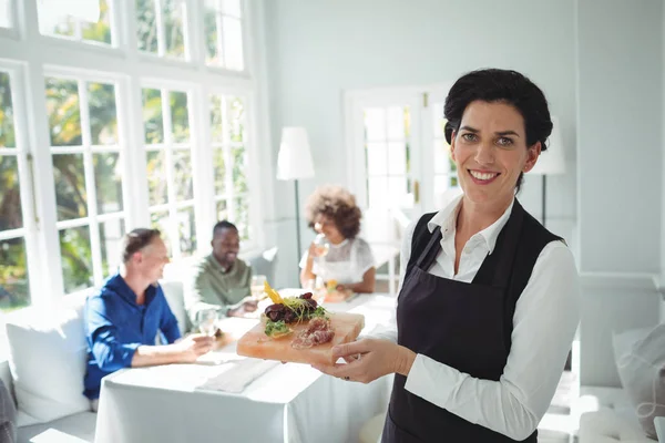 Garçonete sorrindo segurando bandeja de refeição — Fotografia de Stock