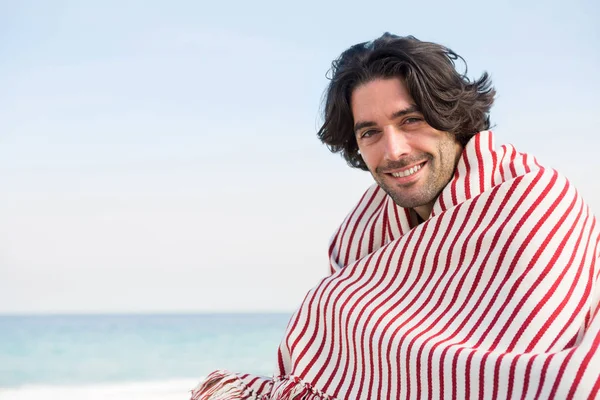 Muž zabalený v šátku sedí na pláži — Stock fotografie