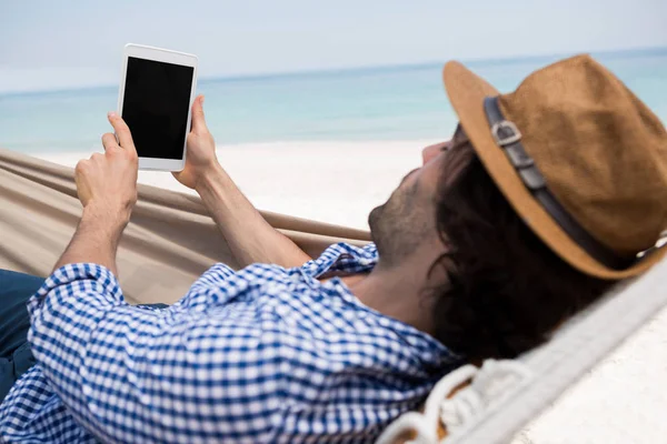 Man met behulp van tablet pc in hangmat — Stockfoto