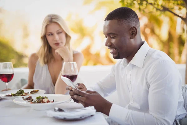 Man ignoring bored woman while using phone — Stock Photo, Image