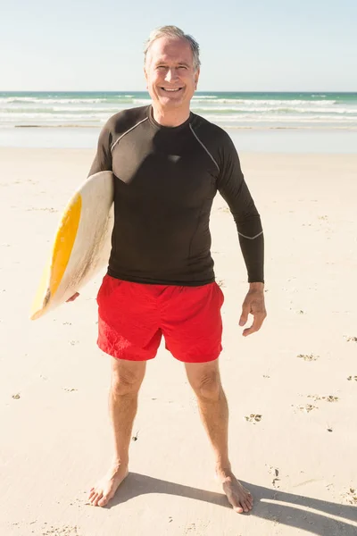 Uomo che trasporta tavola da surf sulla sabbia — Foto Stock