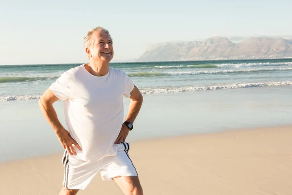 Senior man utövar på sand — Stockfoto