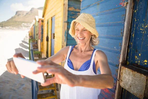 Усміхнена жінка тримає телефон — стокове фото