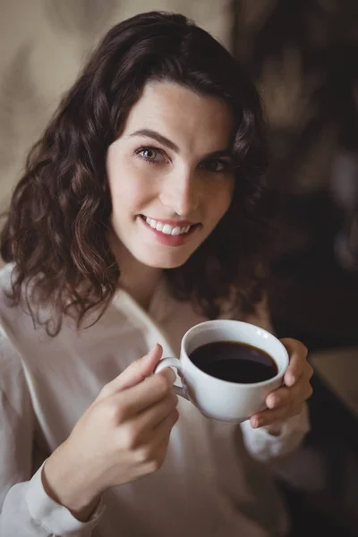 Mujer sosteniendo una taza de café negro —  Fotos de Stock
