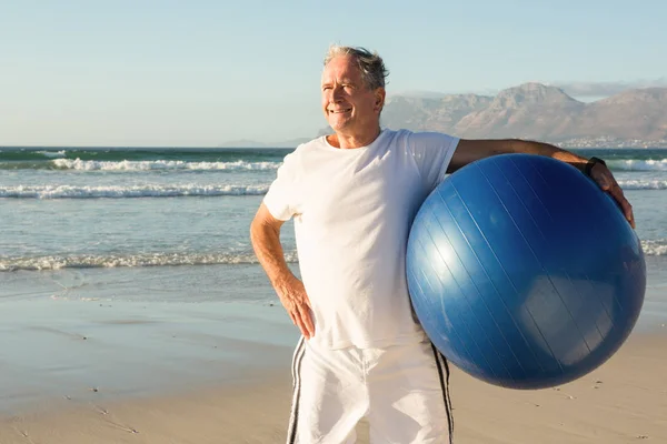 Hombre mayor sosteniendo pelota de ejercicio — Foto de Stock