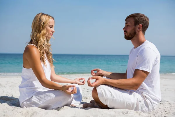 Couple practicing meditation at beach — Stock Photo, Image