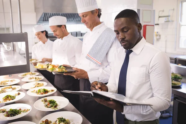 Restaurant manager met zijn keukenbrigade — Stockfoto