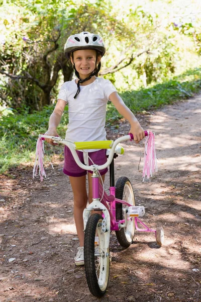 Ragazza sorridente in bicicletta nella foresta — Foto Stock