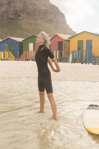 Жінка стоїть з дошкою для серфінгу — стокове фото