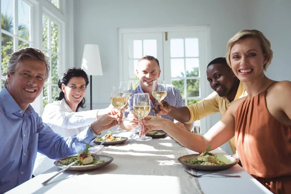 Freunde stoßen mit Weingläsern an — Stockfoto