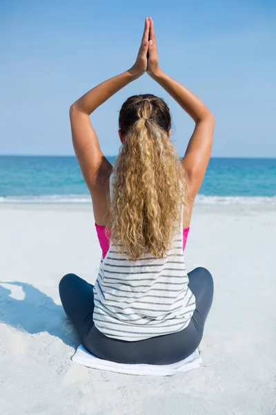 Žena cvičí jógu na pláži v sedle — Stock fotografie