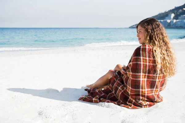 Kvinnan tittar bort när man sitter på stranden — Stockfoto
